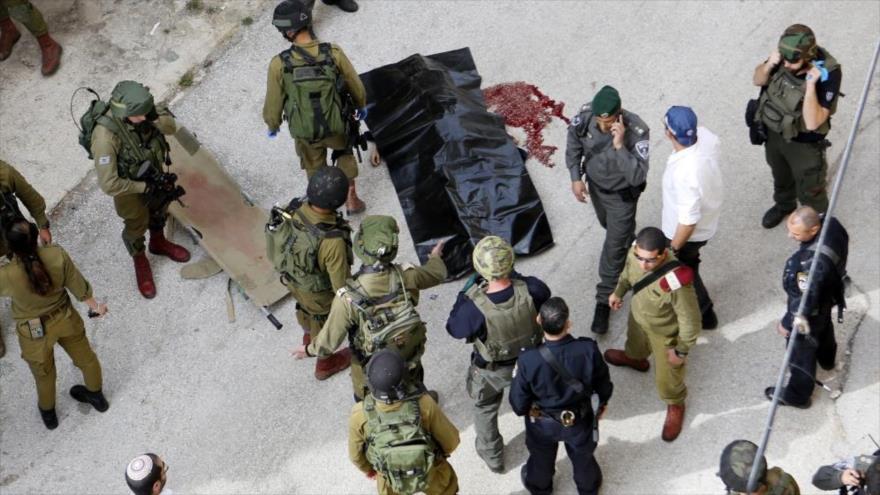 Soldados israelíes congregados en el lugar donde habían matado a una mujer plaestina en la ciudad de Al-Jalil (Hebrón), 13 de febrero de 2016.