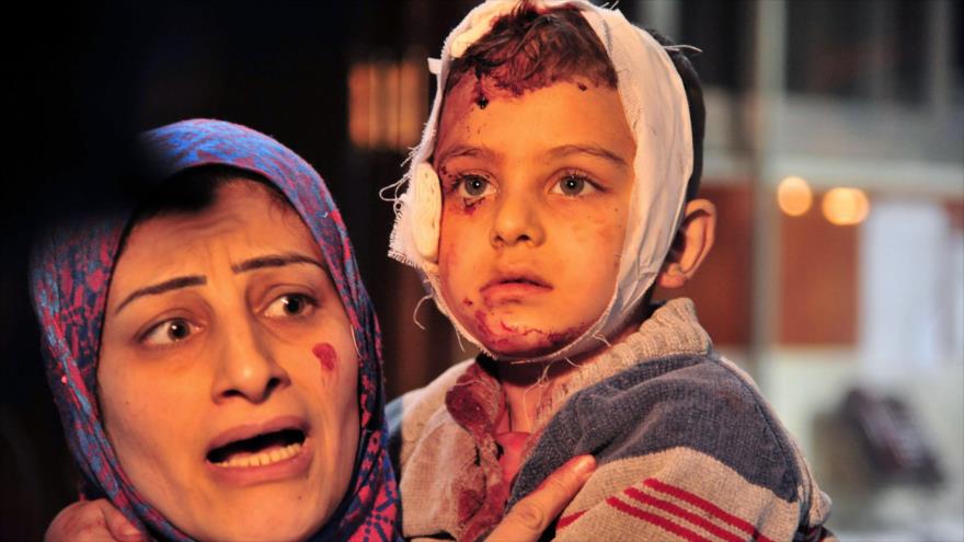 Una madre siria sostiene a su hijo herido en un atentado terrorista cerca del santuario de la Hazrat Zeinab (la paz sea con ella) en Damasco, capital de Siria.