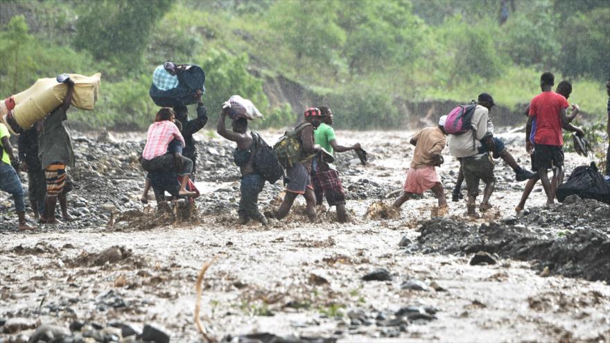 Los haitianos cruzan el río La Digue en la ciudad de Petit Goave (sur de Haiti), donde el puente se derrumbó por el huracán Matthew, 5 de octubre de 2016.
