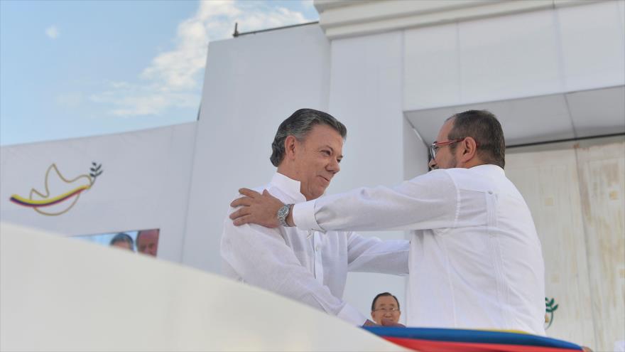El máximo jefe de las FARC, Rodrigo Londoño Echeverri, conocido como Timoshenko (dcha.) y el presidente colombiano, Juan Manuel Santos, se dan un abrazo, 26 de septiembre de 2016.