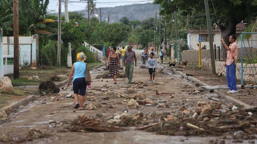 La gente camina por la calle después de que fuertes olas golpearan la costa en la playa de Siboney (este de Santiago de Cuba) luego de la llegada del huracán Matthew, 4 de octubre de 2016.
