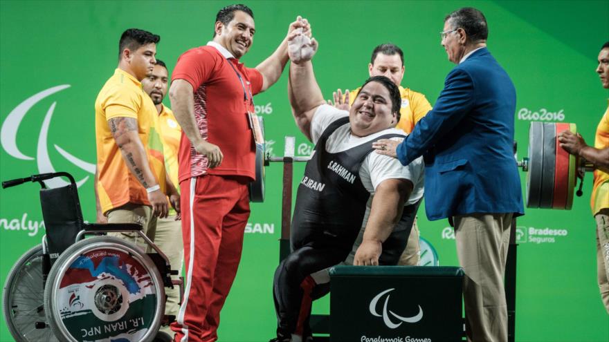 El pesista iraní, Siamand Rahman, celebra con su entrenador el levantamiento de 300 kg, en la prueba de la categoría máxima de press de banca (más de 107 kilogramos) en los Juegos Paralímpicos Río 2016, 14 de septiembre de 2016.