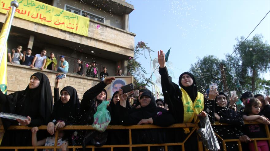 Mujeres libanesas tiran flores durante el funeral de Mohammed Ibrahim Hamza, miembro del Movimiento de Resistencia Islámica de El Líbano (Hezbolá) que murió en combate junto a las fuerzas del Gobierno sirio, 27 de junio de 2016.