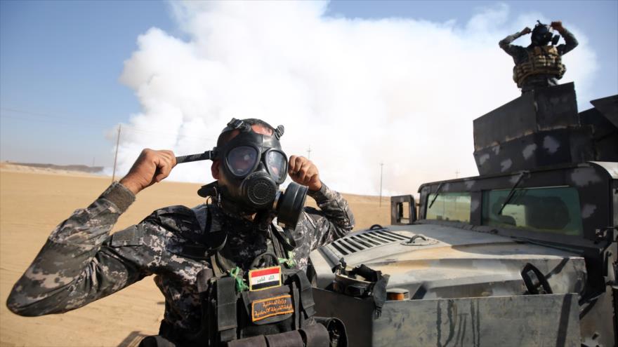 Las fuerzas del Ejército iraquí llevan máscaras de protección para protegerse de los gases tóxicos liberados de una planta de azufre, incendiada por los terroristas de Daesh cerca de Mosul, norte de Irak, 22 de octubre de 2016.