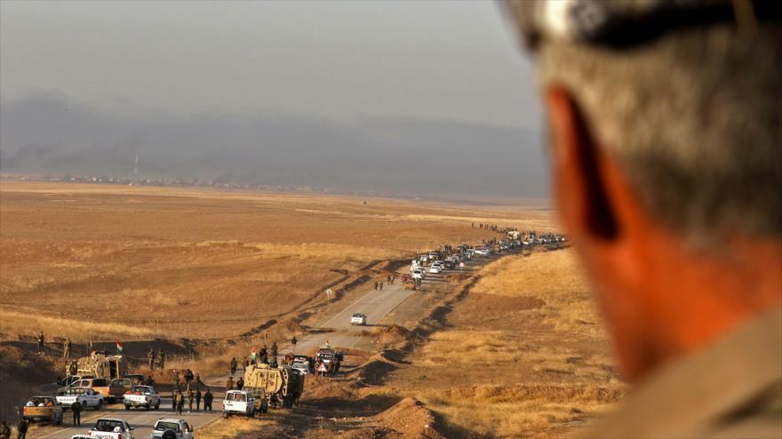 Un combatiente kurdo iraquí vigila la carretera que da a la ciudad de Bashiqa, a 25 kilómetros del noreste de Mosul, 20 de octubre de 2016.