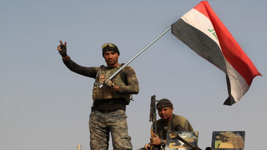 Las fuerzas del Ejército iraquí izan la bandera nacional de su país en el pueblo de Al- Khuwayn, en el sur de la ciudad de Mosul (norte), 23 de octubre de 2016.