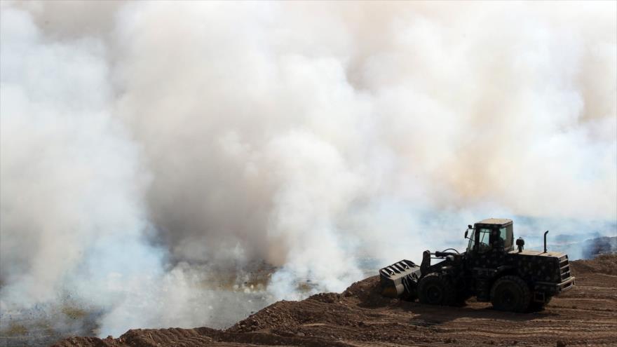 Fuerzas iraquíes intentan extinguir las llamas del fuego prendido por Daesh en la fábrica de azufre de Mashriq, cerca de Al-Qayara, a unos 30 kilómetros al sur de Mosul, 22 de octubre de 2016.