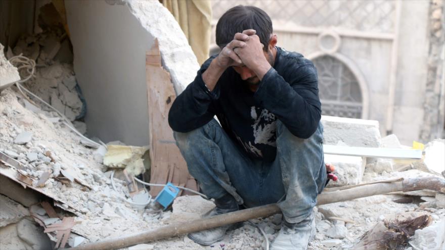 Un hombre sirio sentado en los escombros de edificios devastados en la ciudad norteña de Alepo, 4 de octubre de 2016.
