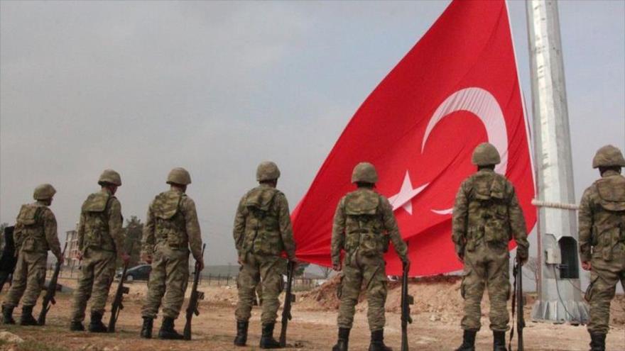 Soldados turcos izan la bandera nacional de Turquía en la zona de Silopi, fronteriza con el norte de Irak.