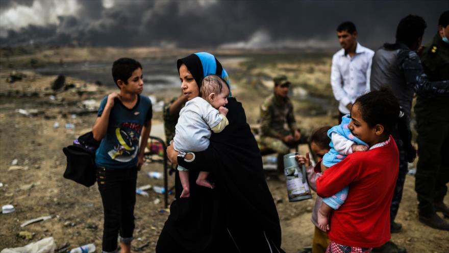 Familias residentes en las regiones aledañas de la ciudad de Mosul abandonan sus casas ante los enfrentamientos entre fuerzas iraquíes y EIIL, 24 de octubre de 2016.