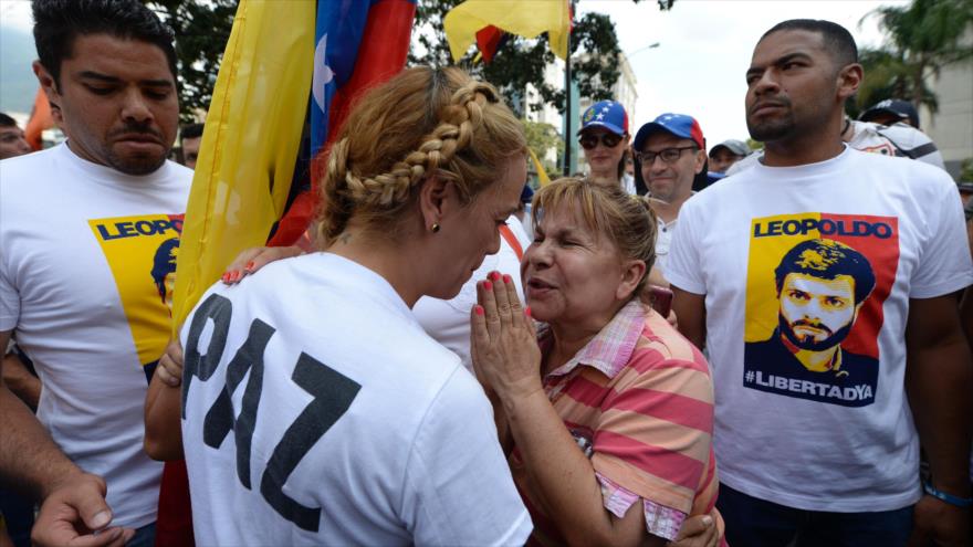 
Lilian Tintori (aparece de espalda), esposa del encarcelado dirigente opositor Leopoldo López, presta atención a una mujer durante una manifestación contra el presidente del Gobierno de Venezuela, Nicolás Maduro, en la capital del país, Caracas, 26 de octubre de 2016.
