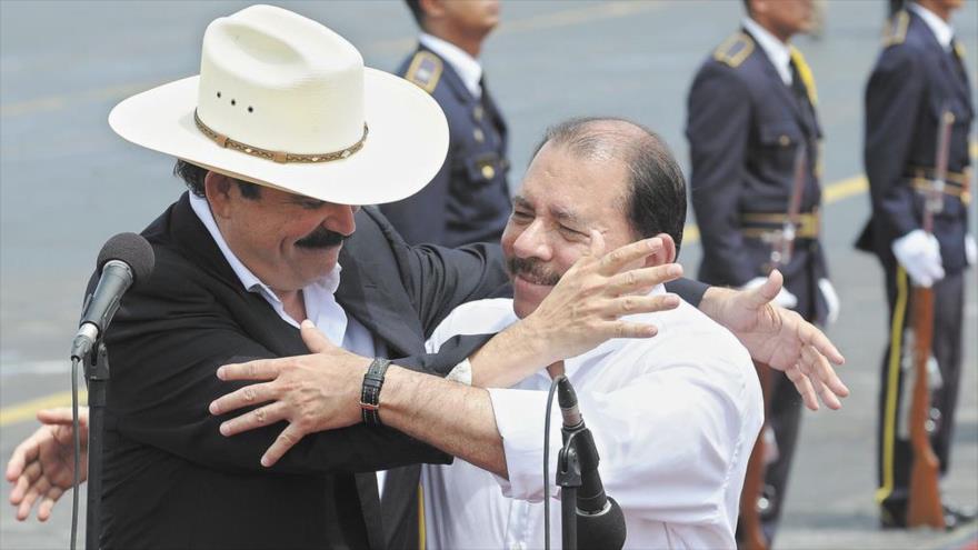 El presidente de Nicaragua, Daniel Ortega (dcha.), y el exmandatario hondureño, Manuel Zelaya se abrazan en el aeropuerto de la capital nicaragüense, Managua.