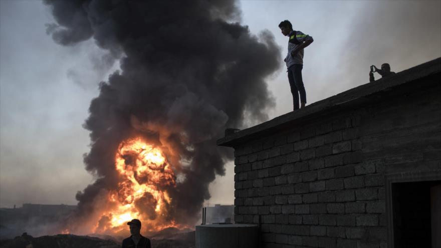 Civiles iraquíes observan desde lejos las llamas procedentes de un pozo petrolífero en Qayyarah, cerca de Mosul, 3 de noviembre de 2016.