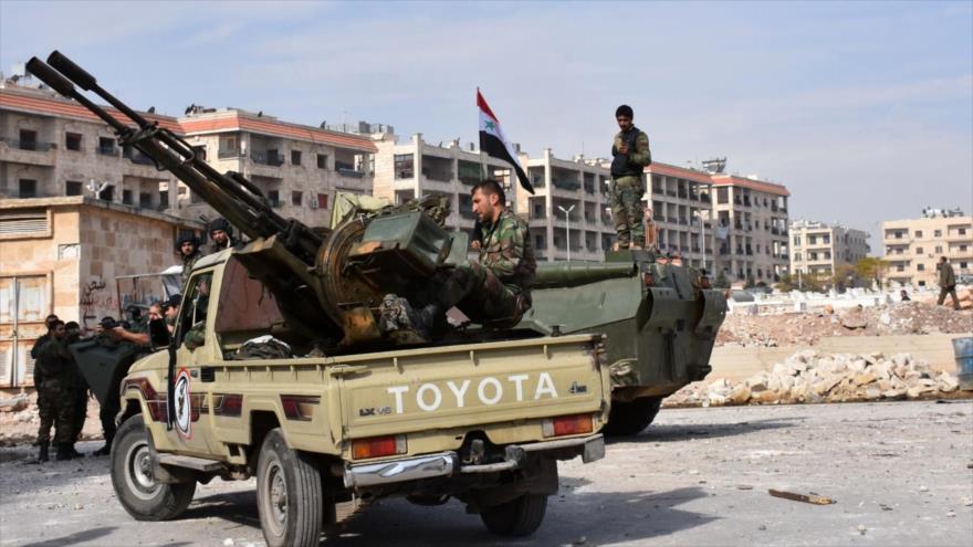Fuerzas del Ejército sirio se agrupan cerca de sus vehículos en el recién liberado distrito de Minyan, en Alepo, 12 de noviembre de 2016.