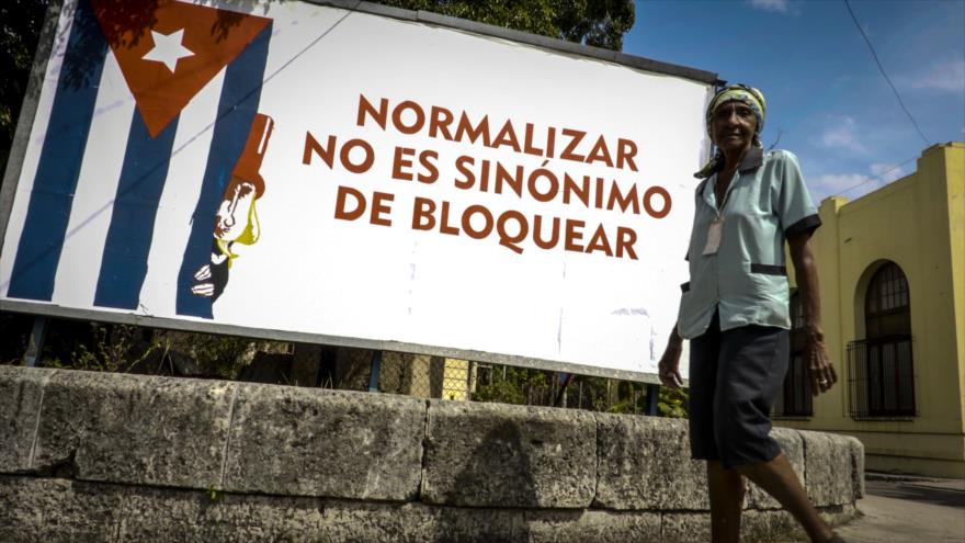 Una mujer pasa frente a un cartel contra el bloqueo estadounidense a Cuba, en La Habana, 26 de octubre de 2016.