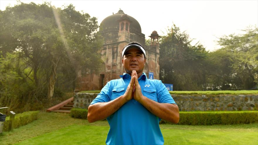 Un ciudadano de Singapur realiza un ejercicio de yoga delante de la Panasonic Open India en Nueva Delhi, la capital de La India, 30 de noviembre de 2016.