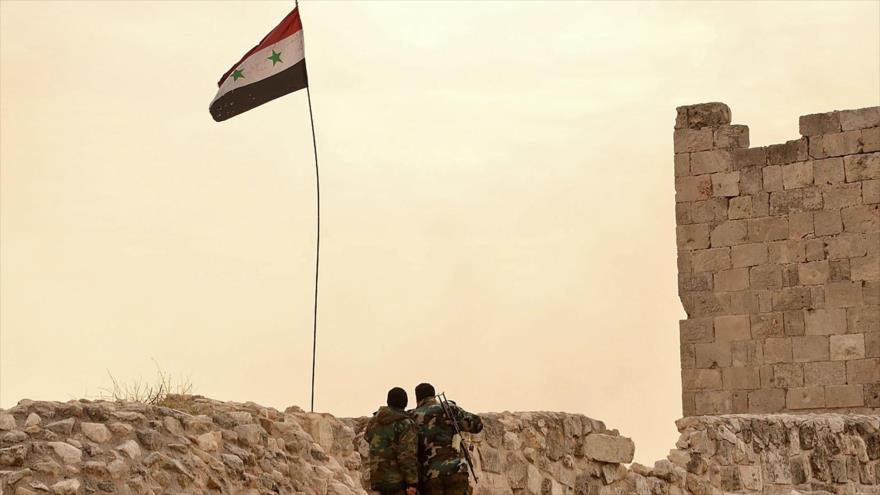 Soldados del Ejército de Siria izan la bandera del país tras liberar un barrio en la parte oriental de la ciudad de Alepo de manos terroristas, 7 de diciembre de 2016.