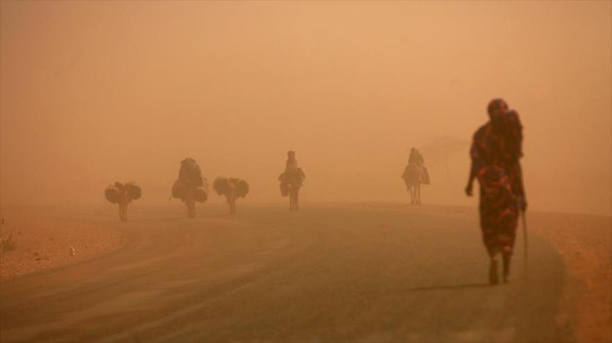 Un grupo de sudaneses atraviesa una tormenta de arena en el norte de Darfur, situado en el oeste de Sudán, 13 de abril de 2010.