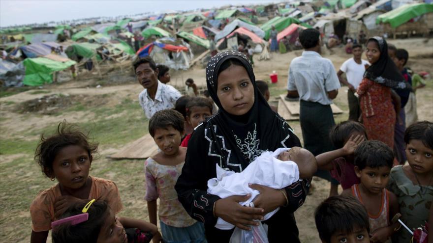 Una mujer musulmana Rohingya, una minoría de Birmania (Myanmar), sujeta a su bebe recién nacido en un campo de refugiados, mayo de 2013.