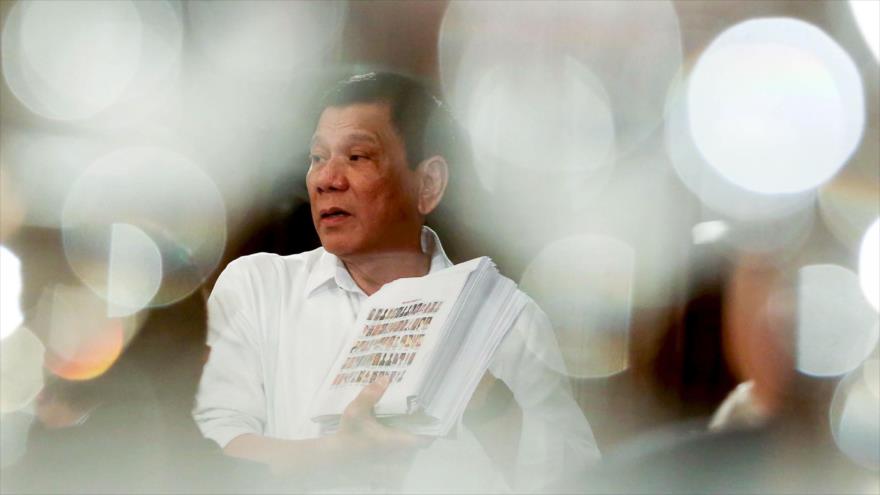 El presidente filipino, Rodrigo Duterte, muestra una lista de policías y funcionarios gubernamentales involucrados en drogas ilegales durante un foro con empresarios locales y extranjeros en el palacio de Malacanang en Manila, 12 de diciembre de 2016.