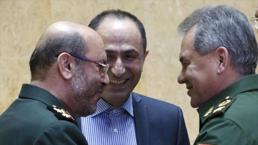 El ministro ruso de Defensa, Serguei Shoigu (dcha.), habla con su par iraní, Husein Dehqan, tras reunirse en Moscú (capital de Rusia), 16 de febrero de 2016.