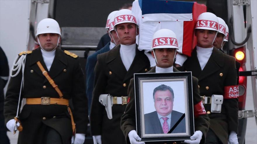 Las fuerzas turcas llevan el ataúd del embajador ruso Andrei Karlov y una de sus fotos durante una ceremonia de despedida antes de enviar su cuerpo a Rusia, 20 de diciembre de 2016.