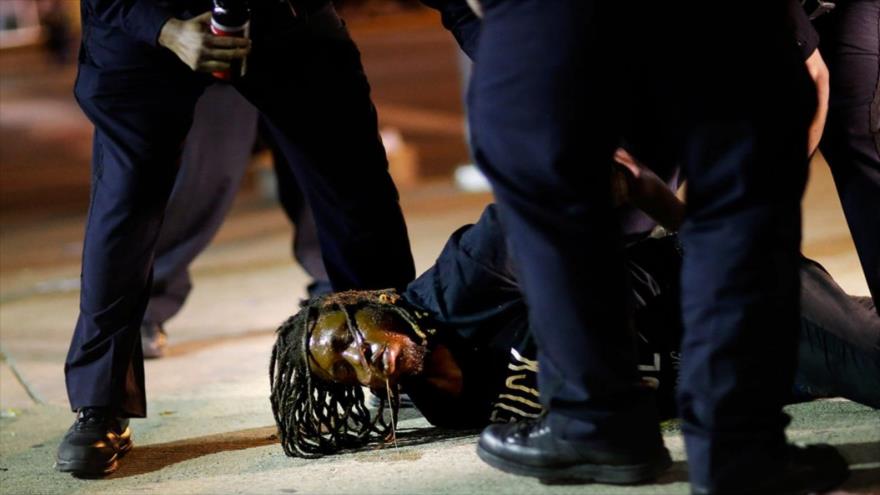 Agentes de la Policía de Estados Unidos detienen a un ciudadano afrodescendiente durante una protesta.