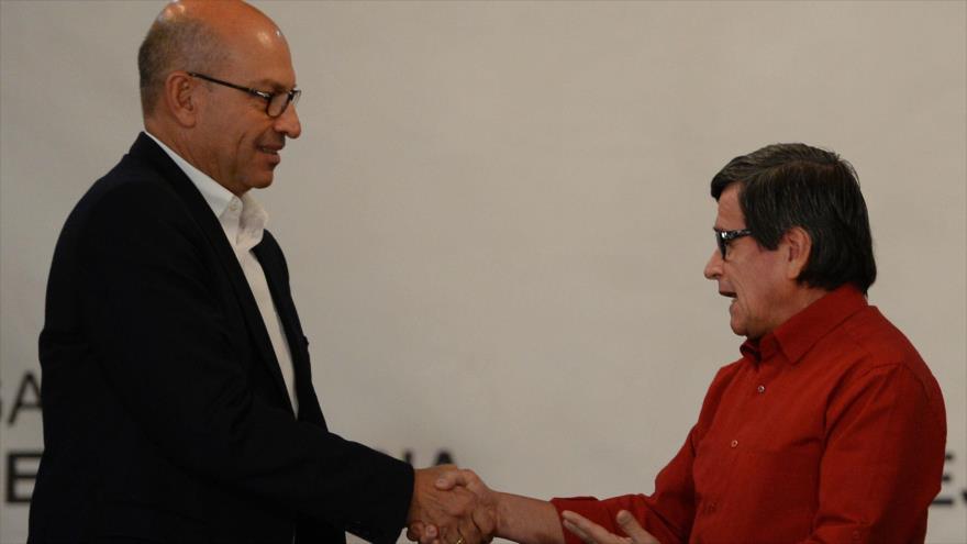 El jefe de la delegación del Gobierno colombiano para los diálogos de paz, Mauricio Rodríguez (izda.), estrecha la mano del portavoz de la guerrilla del ELN, Pablo Beltrán, Caracas, 10 de octubre de 2016.