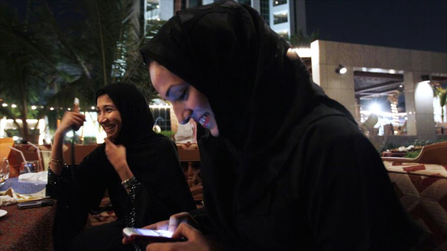 Mujeres saudíes con teléfonos celulares fuman tabaco en la ciudad de Yedda, septiembre de 2010.