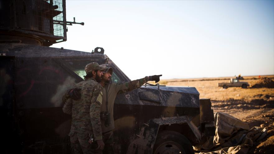 Un miembro de Al-Hashad Al-Shabi, conocido también como las Unidades de Movilización Popular (PMU, por sus siglas en inglés) demuestra a su compañero la dirección donde los terroristas de EIIL (Daesh, en árabe) están disparando contra sus posiciones en Tal Afar, cerca de Mosul, 20 de noviembre de 2016.