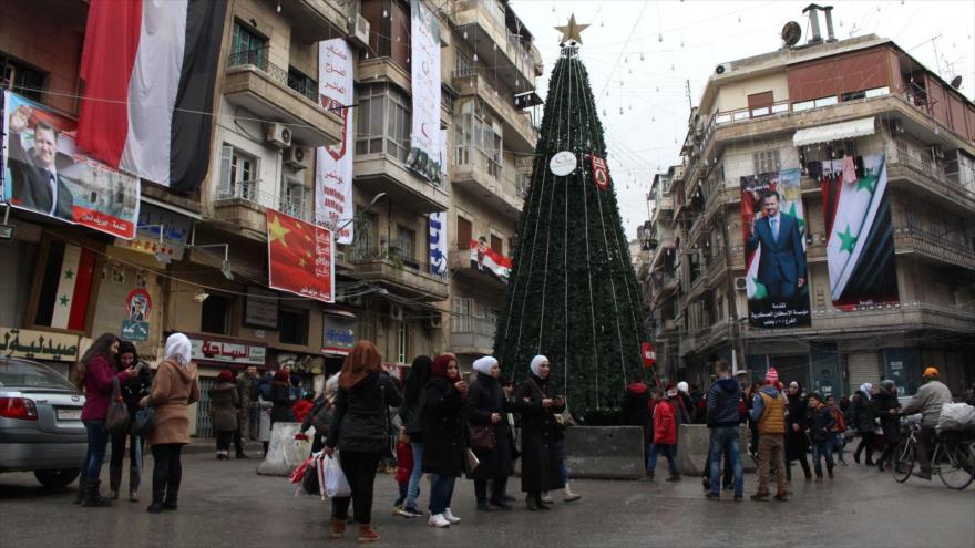 Los sirios se reúnen alrededor de un árbol de Navidad en Alepo (noroeste) mientras está en vigor un alto el fuego, 31 de diciembre de 2016.