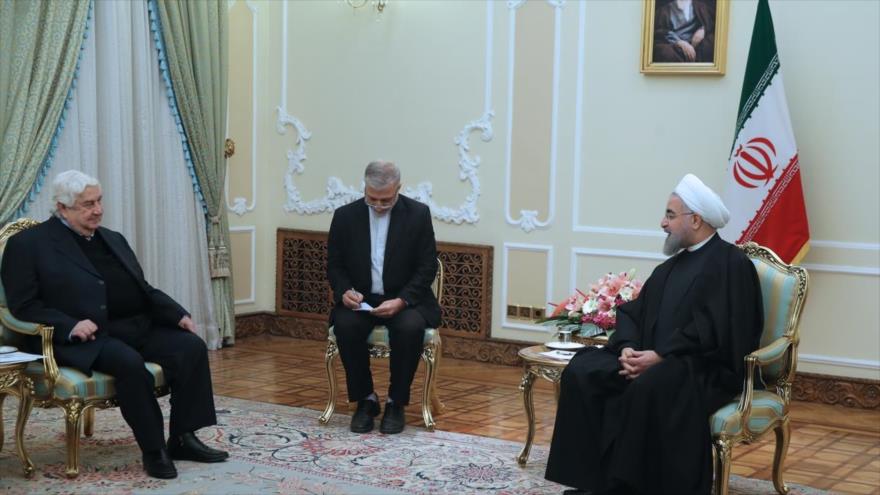 El presidente iraní, Hasan Rohani (dcha.), durante un encuentro con el canciller sirio, Walid al-Moalem, en Teherán, 31 de diciembre de 2016.