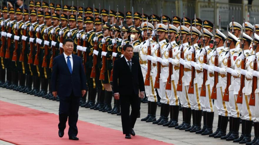 El presidente de Filipinas, Rodrigo Duterte (dcha.), junto a su homólogo chino, Xi Jinping, pasan revista a la guardia de honores en Pekín, capital china, 20 de octubre de 2016.