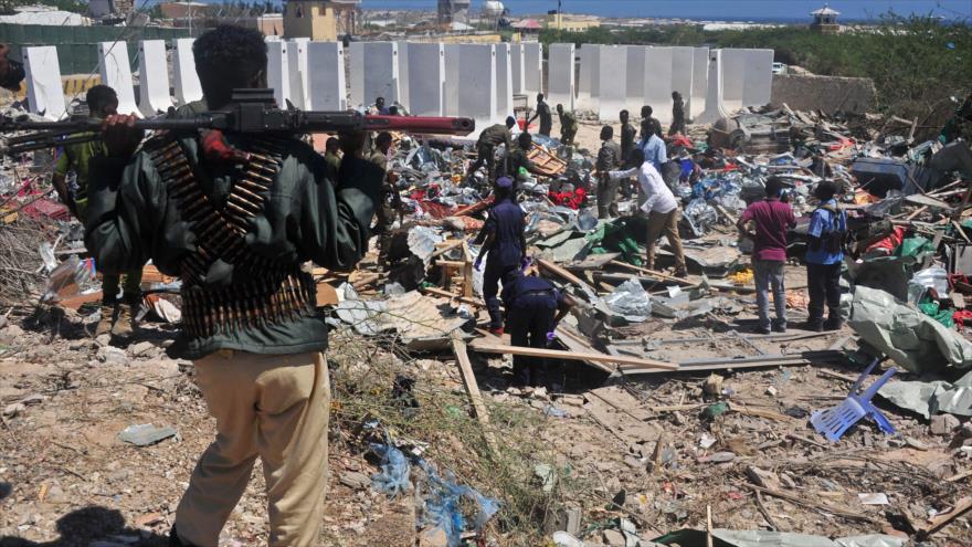 Los civiles y los soldados están presentes en la escena de un atentado con coche bomba cerca de un hotel en Mogadiscio (capital de Somalia), 2 de enero de 2017. 