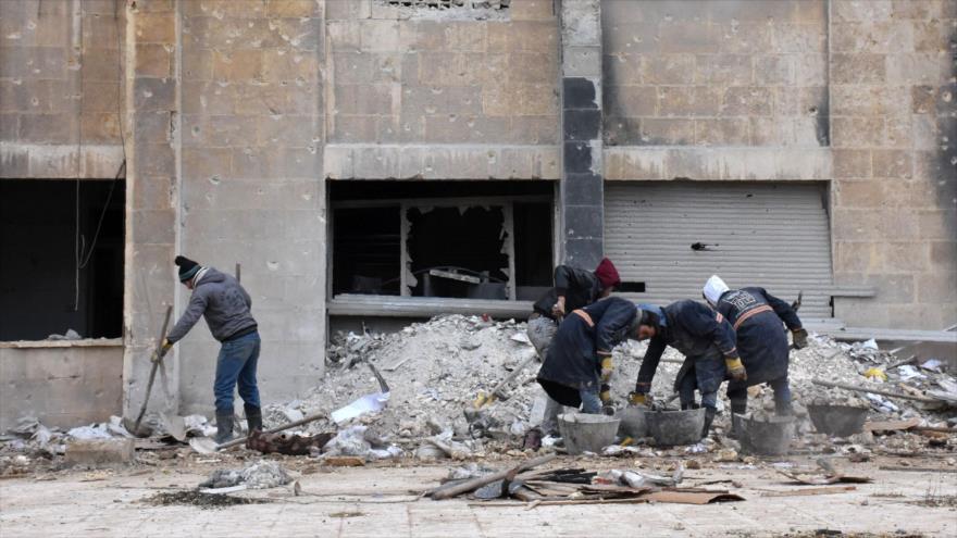 Trabajadores sirios retiran los escombros en el barrio Suleiman al-Halabi de Alepo (noroeste de Siria), 27 de diciembre de 2016.