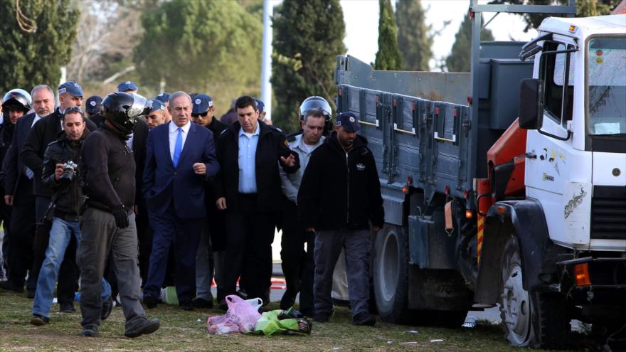 El primer ministro israelí, Benyamin Netanyahu (centro), visita el lugar donde un conductor palestino embistió con su camión a un grupo de soldados israelíes, 8 de enero de 2017.