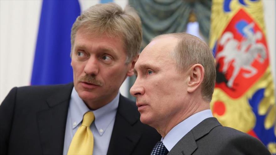 El portavoz del Kremlin, Dmitri Peskov (izqda.) habla con el presidente ruso, Vladimir Putin.