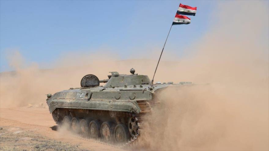 Un vehículo blindado del Ejército sirio circula por una localidad en el centro del país.