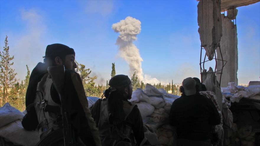 Combatientes de la coalición terrorista Yaish al-Fath (o Ejército de la Conquista) observan una columna de humo desde uno de los puntos de entrada a Alepo, en Siria, 3 de noviembre de 2016.