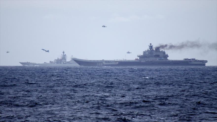 Helicópteros rusos escoltan el portaaviones ruso Admiral Kuznetsov (dcha.) y el crucero pesado Pyotr Velikiy del Ejército de Rusia en su rumbo a las aguas internacionales en el Mediterráneo, 18 de octubre de 2016.