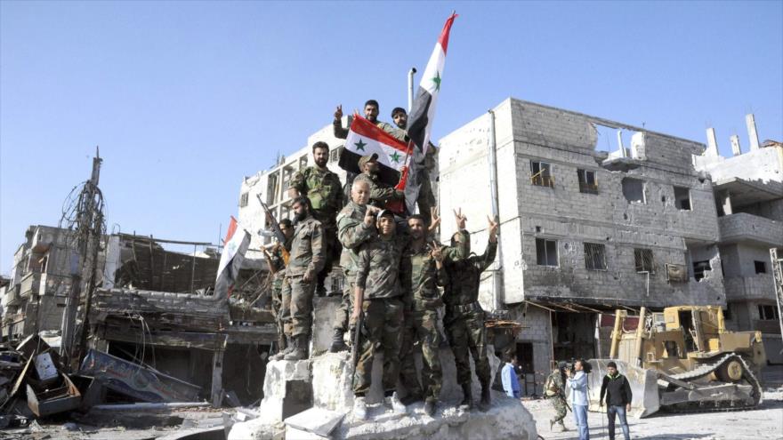 Soldados del Ejército de Siria celebran su avance antiterrorista en Damasco, la capital.