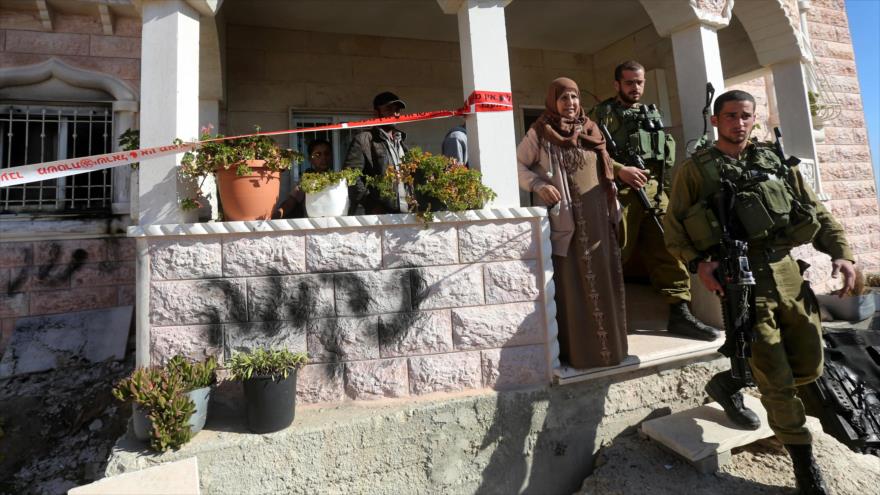 Soldados israelíes salen de una casa palestina en la Cisjordania ocupada tras haberla registrado.