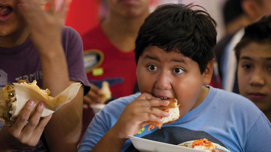 Un chico come una pieza de una megatorta en la Ciudad de México, donde los cocineros prepararon una torta de 170 pies de largo para tratar de establecer un récord mexicano.