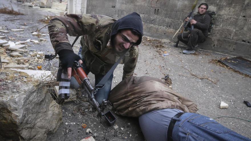 Un combatiente del Ejército Libre Sirio (ELS) ayuda a un compañero herido durante los combates en Alepo, en noroeste de Siria.