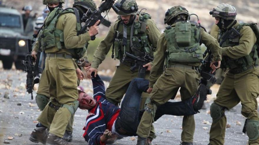 Soldados israelíes golpean a un palestino durante manifestaciones antisraelíes.