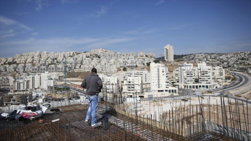 Un obrero contempla los asentamientos israelíes en Al-Quds (Jerusalén). 