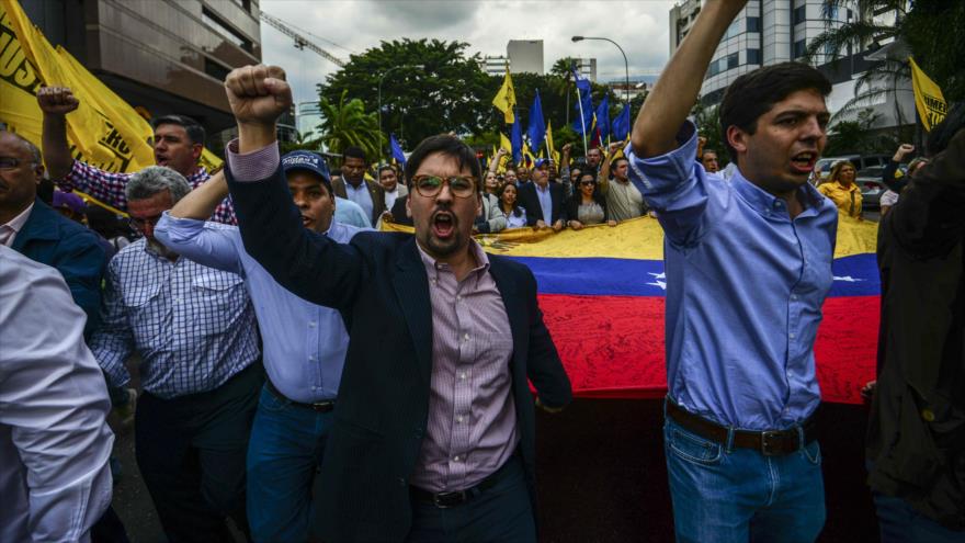 El primer vicepresidente de la Asamblea Nacional venezolana, Freddy Guevara (centro) y otros diputados de la oposición cantan consignas mientras marchan a la sede de la Organización de Estados Americanos (OEA) durante una protesta en Caracas, 18 de enero de 2017.