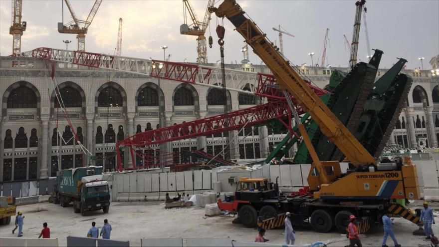Trabajadores caminan junto a la grúa que se derrumbó el día anterior en la Mezquita de Al-Haram, en la sagrada ciudad saudí de La Meca, 12 de septiembre de 2015.