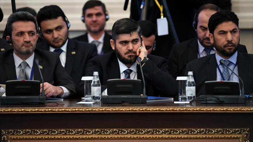 Mohamad Alloush (centro), uno de los líderes del grupo armado sirio Yeish al-Islam, escucha un discurso en la reunión de Astaná (capital kazaja) sobre Siria, 23 de enero de 2017.