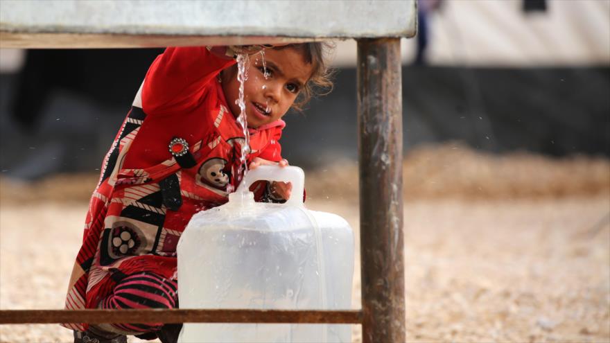 Una niña iraquí llena un recipiente con agua en el campo de refugiados de Al-Hol, 5 de diciembre de 2016.